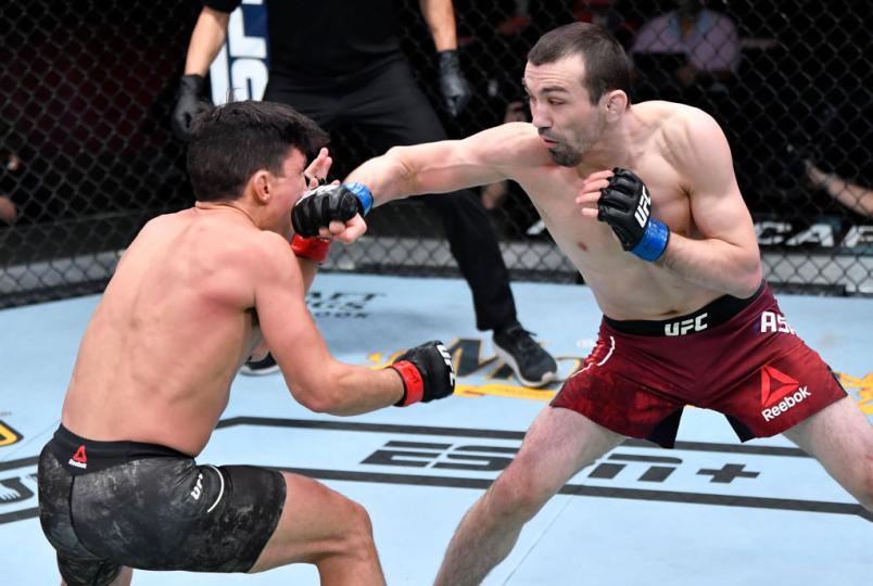 Askar Askaarov of Russia punches Joseph Benavidez in their flyweight fight during the UFC 259 event at UFC APEX on March 06, 2021 in Las Vegas, Nevada. (Photo by Jeff Bottari/Zuffa LLC)